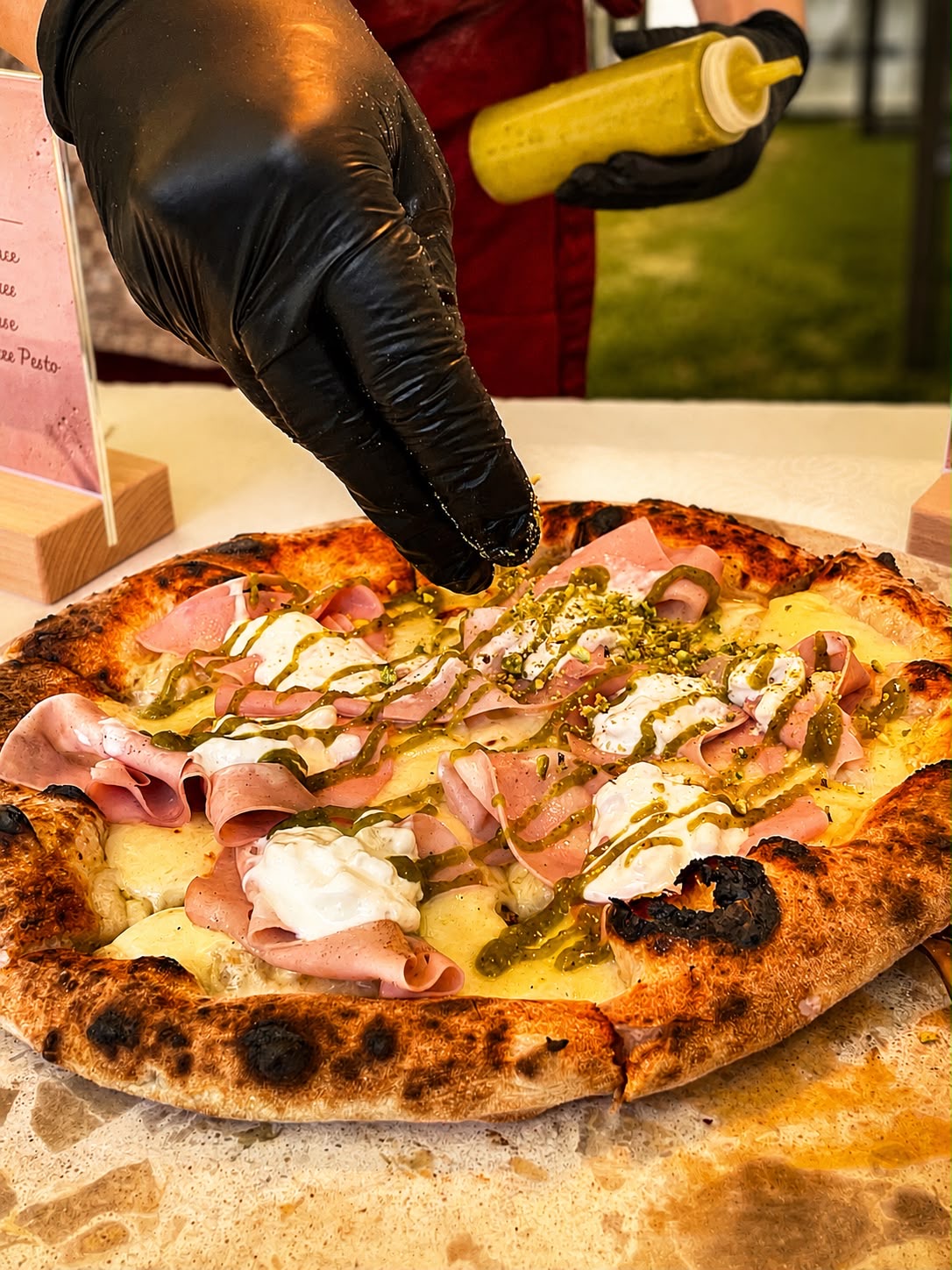 Handgemachte Pizza mit Mortadella, Stracciatella und Pistazienpesto